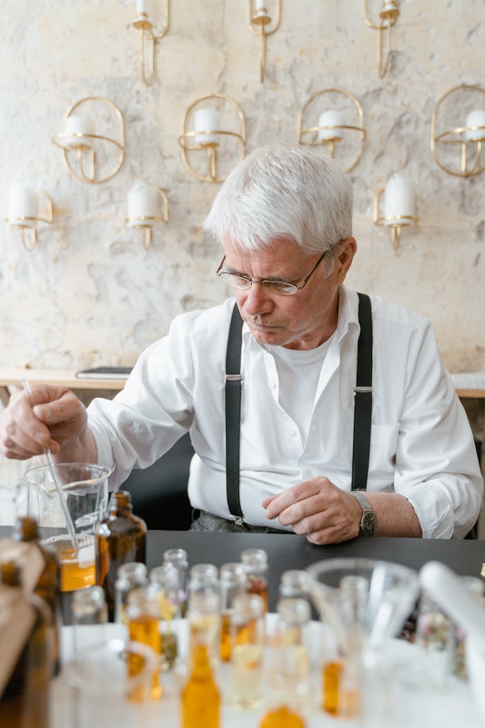 why-choose-us Elderly man mixing liquids in a laboratory setting for perfume making.